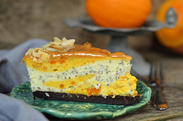 Slice of pumpkin and chia cheesecake with caramel topping on wooden background