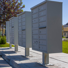 White mailboxes with shadows on the sidewalk