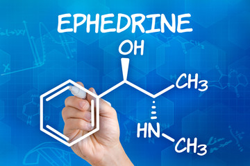 Hand with pen drawing the chemical formula of ephedrine