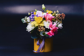 colored bouquet in basket on dark background