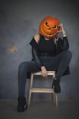 Woman with carved pumpkin on her head for Halloween