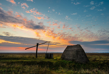 ancient drawing well at sunset in the National Park Neusiedlersee Seewinkel in Apetlon Burgenland Austria