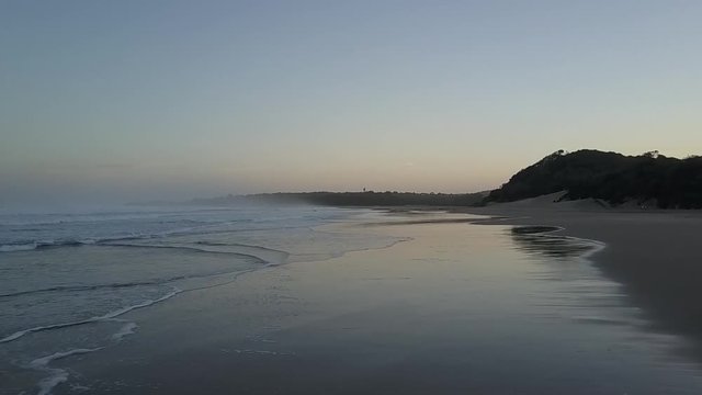 Shallow waves hitting shoreline during sunset
