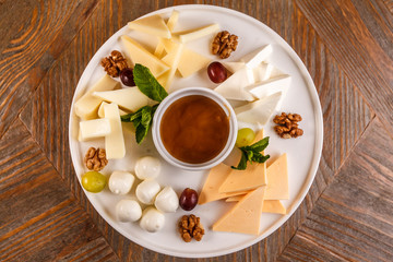 Cheese plate Assortment of various types of cheese and honey on white plate