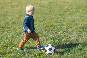 Little child play football in the park