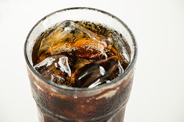 Cola with ice in glass top view