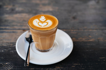 cup of flat white coffee on a wooden table