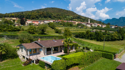 Fototapeta na wymiar Aerial view of house with swimming pool in the countryside with hills
