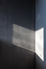 Walls painted in gray, sunlight falls on the walls through the window
