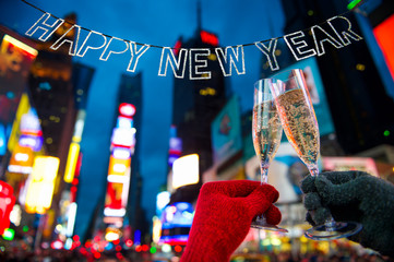 Happy New Year glitter bunting hangs in celebration over bright neon lights of Times Square in New...