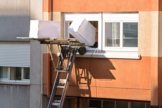 Moving Company Working With Elevator In Building Exterior