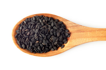 Black sesame seeds in wooden spoon isolated on white background