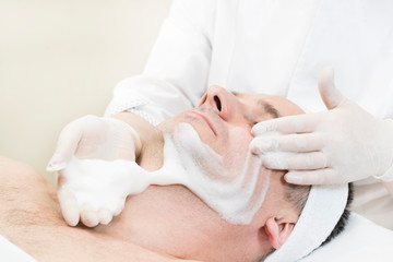 Man in the mask cosmetic procedure in spa salon. 