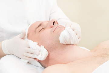 Obraz na płótnie Canvas Man in the mask cosmetic procedure in spa salon. 