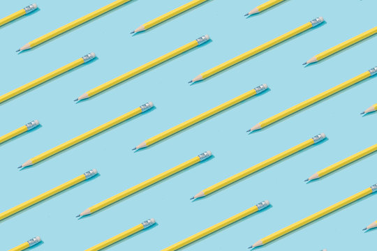 Pattern composition of yellow pencils on pastel blue background. Minimalist isometric concept.