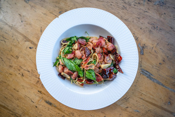 Homemade bacon Spaghetti Spicy with ingredient on wood table with Natural light.