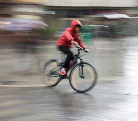 Cyclist on the city roadway on a rainy day in motion blur