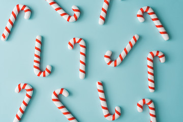 Creative minimal Christmas art. Pattern made with Christmas candies on bright blue background. Flat...
