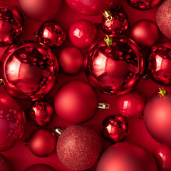 Red Christmas baubles decoration on red background. New Year party background. Minimal style.  Flat lay.