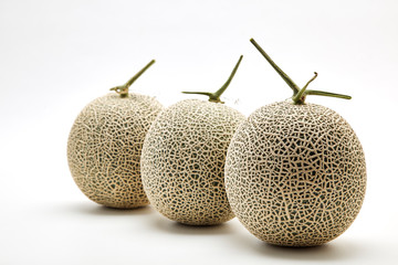 Three cantaloupe melon on white