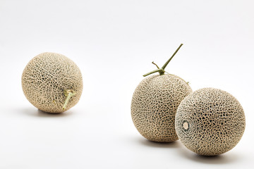 Three cantaloupe melon on white