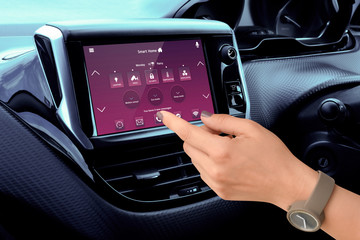 Woman control home temperature and security with smart home app in car.