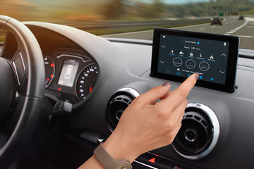 Fototapeta premium Woman driver control home temperature and security with smart home app in car. Home temperature, safety and environment control on in-car display.