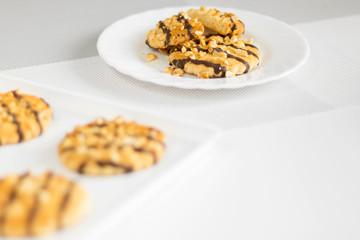 Shortbread cookies with nuts and chocolate on a plate and tray