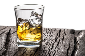 Whiskey glass or glass of whiskey with ice cubes on the table at white background.