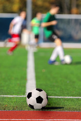 Fototapeta premium Boys playing a football match and empty space for text