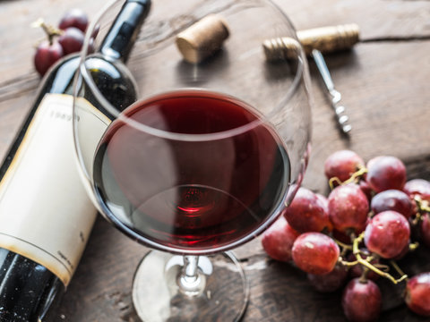 Fototapeta Wine glass, wine bottle and grapes on wooden background. Wine tasting.