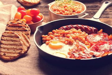 Traditional english breakfast food with eggs sausages bacon beans and toasts