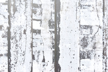 Close-up of vertical strips of white torn paper on a light gray metal background  