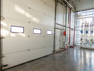 large closed gate with windows in the factory. pipes and motor