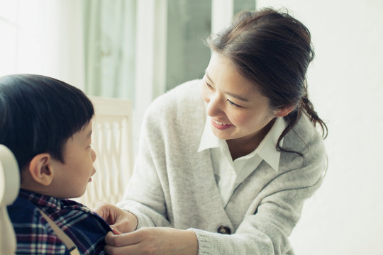 子供のボタンを留める母親