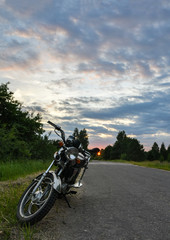 Fototapeta premium Motorower na drodze o zachodzie słońca