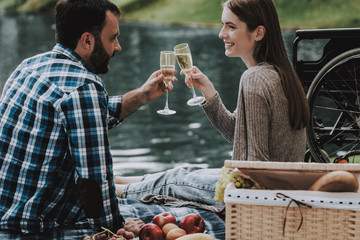 Girl on Wheelchairs with Man on Picnic in Park.