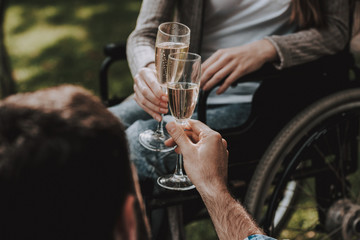 Girl on Wheelchairs with Man on Picnic in Park.