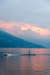 Yacht cruising fast at sunset on Lake Como
