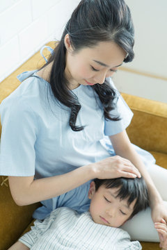 寝ている子供と膝枕をする母親
