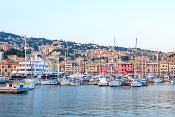 Fototapeta na wymiar Ships parked in Porto Antico at sunset
