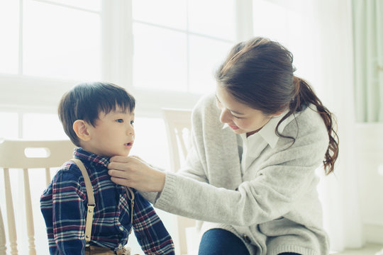 子供のボタンを留める母親