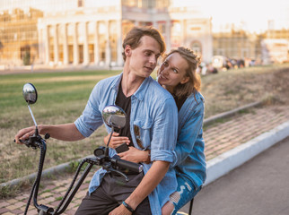 Fototapeta na wymiar Lovely young couple driving electric bike during summer. Modern city dating and transportation
