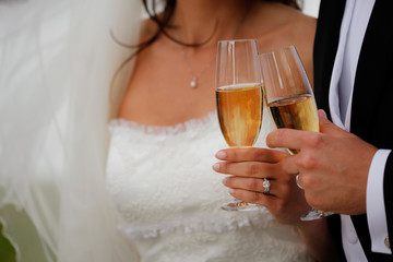 Close up of bride and groom toasting with champagne glasses