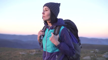 girl climber with a big backpack in the mountains