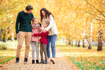 Portrait of happy family of four in autumn day