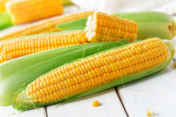 Raw corn on a wooden table