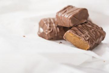 CHOCOLATE BARS WITH TOFFEE CARAMEL ON WHITE NAPKIN (COPY SPACE)