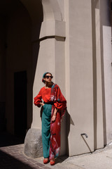 Fashion portrait of young spanish woman in sunglasses. Fashion latin look. Woman walking in old town