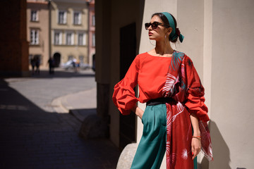 Fashion portrait of young spanish woman in sunglasses. Fashion latin look. Woman walking in old town